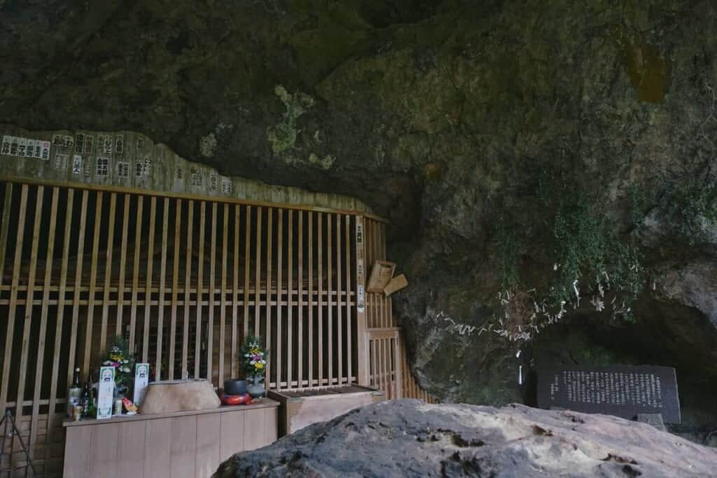 large stone and small shrine inside Reigando cave in Japan