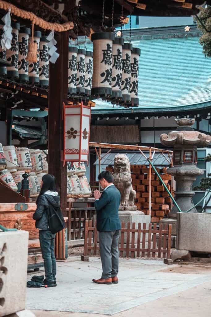 People praying at Osaka Tenmangu Shrine in Japan