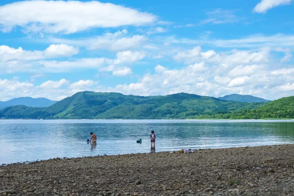 A family bathes in a lake in Akita, 
 Japan