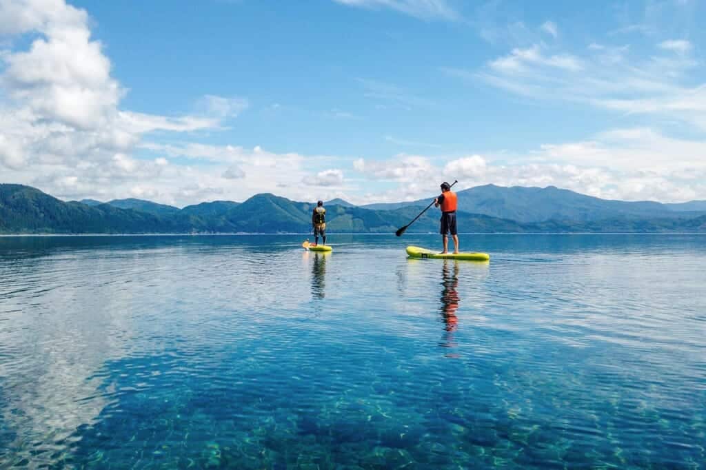 Two people doing SUP on Lake Tazawa in Akita, Japan
