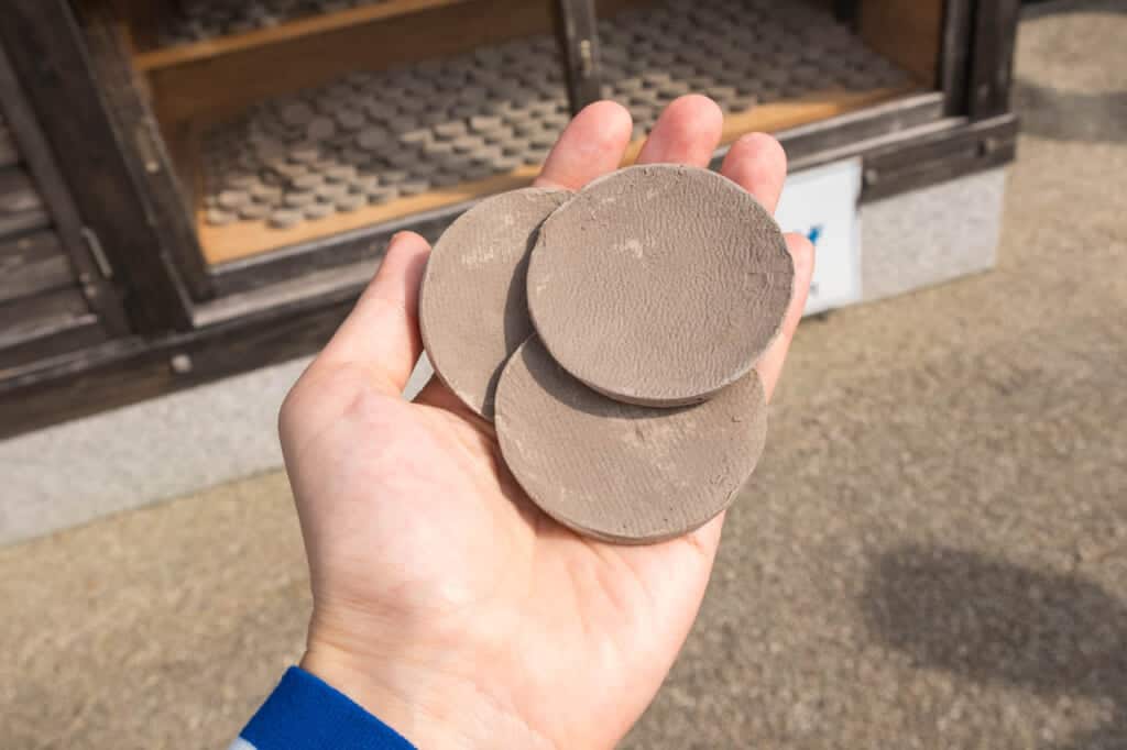 3 clay discs in palm of hand