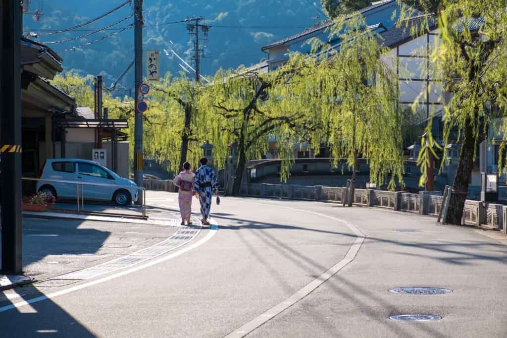 Yukata couple walking down Japanese street in Kinosaki