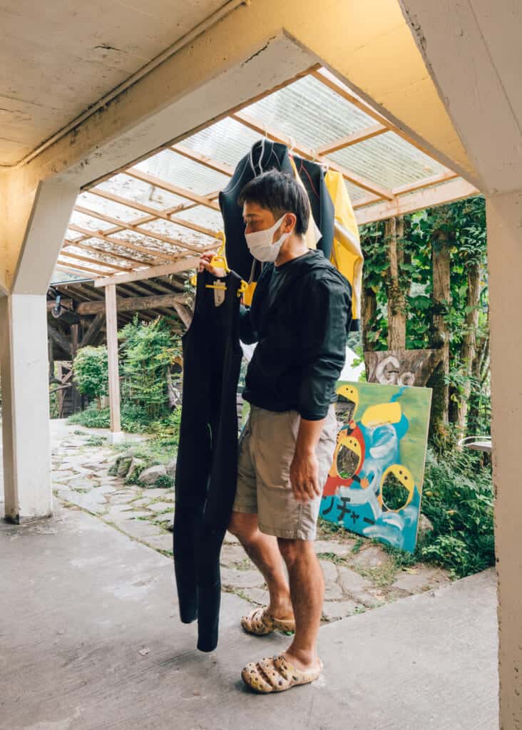 man holding wetsuit at go go adventure, Shikoku