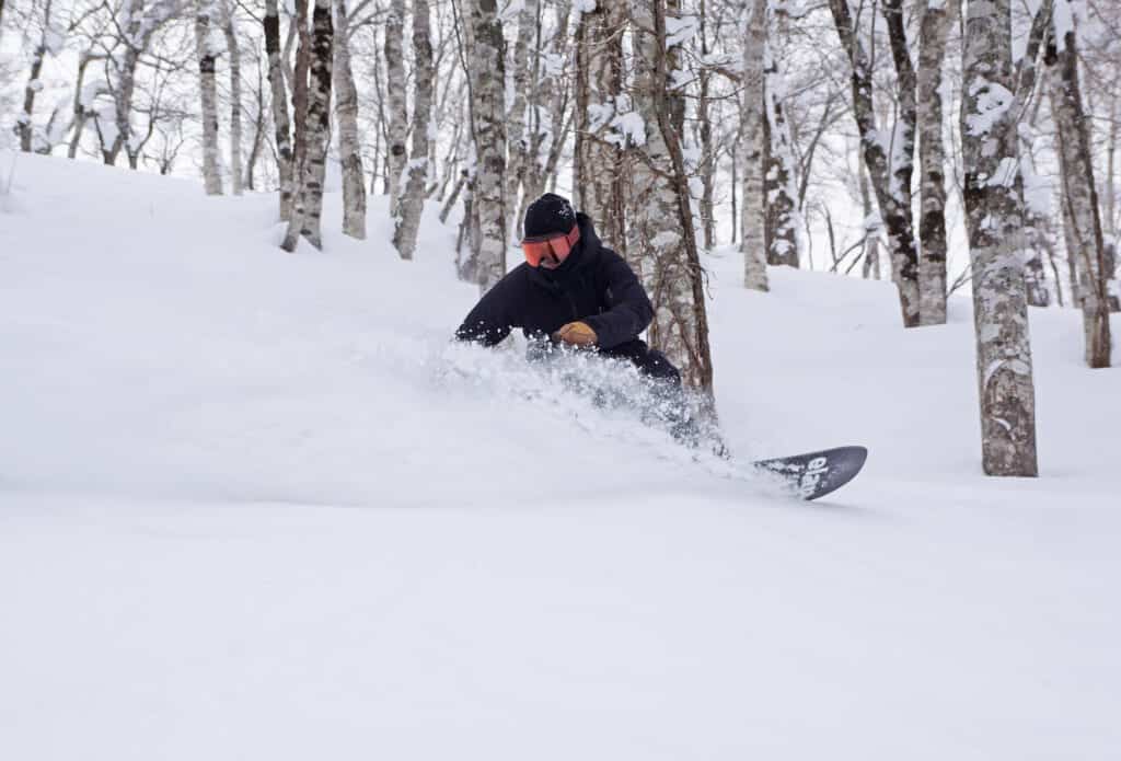 Snowboarder going down fresh powder snow at Rusutsu