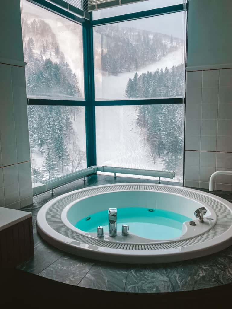 Jaccuzi inside Hoshino Resorts Tomamu rooms with beautiful views of the slope