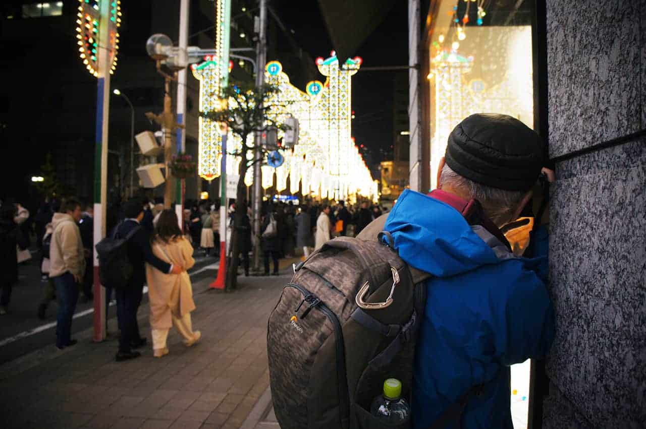 Photographer looking for an original angle of the Luminarie