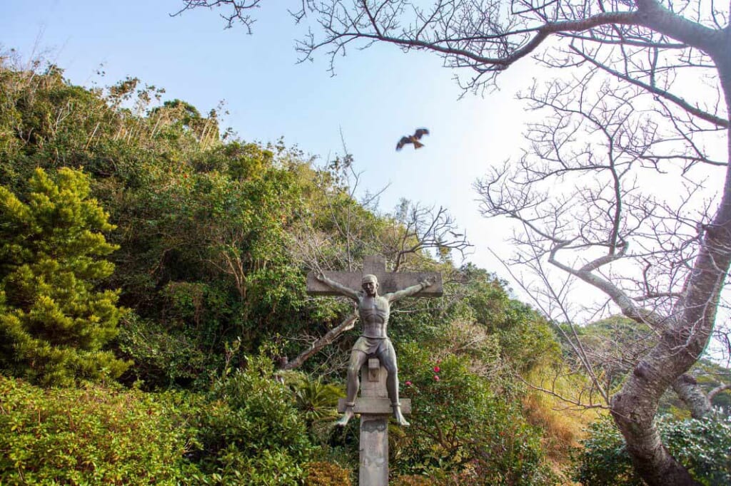 Bird flying over Christian statue in Japan