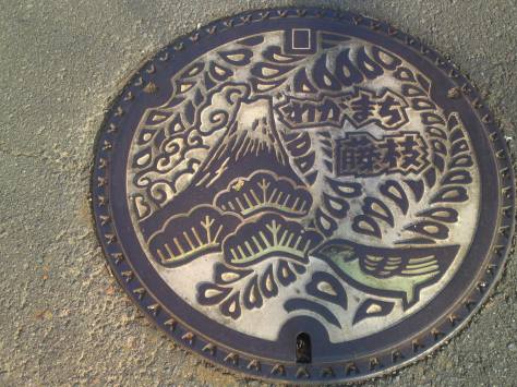 A manhole design with Mt. Fuji, a bird and wisteria flowers.