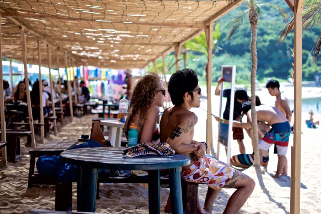 tattooed person sitting at a beach in Japan