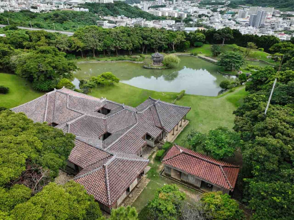 Okinawa royal garden with central pond and traditional buildings