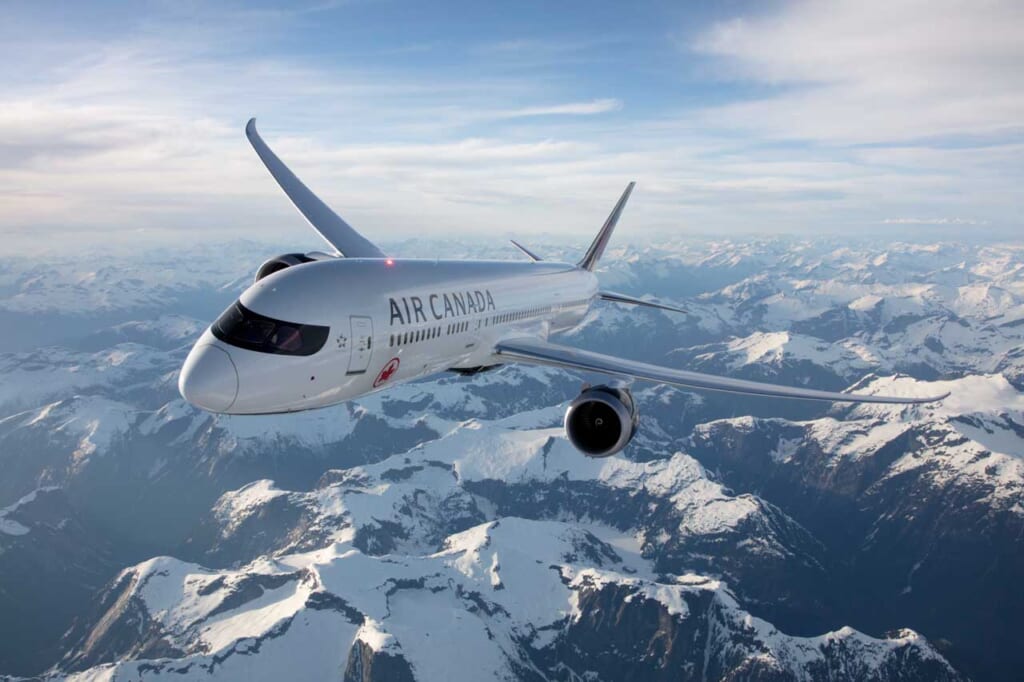 air canada plane over snowy mountains