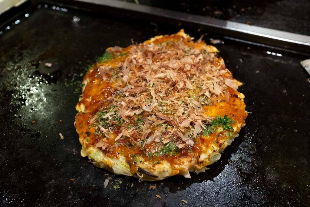 Okonomiyaki being cooked on a hot plate in a restaurant in Asakusa, Tokyo 