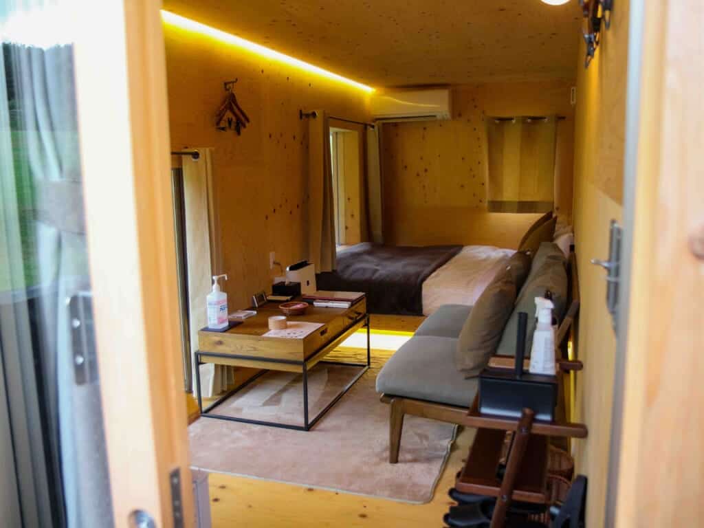 interior of the glamping room with a cozy couch, tea table, and bed