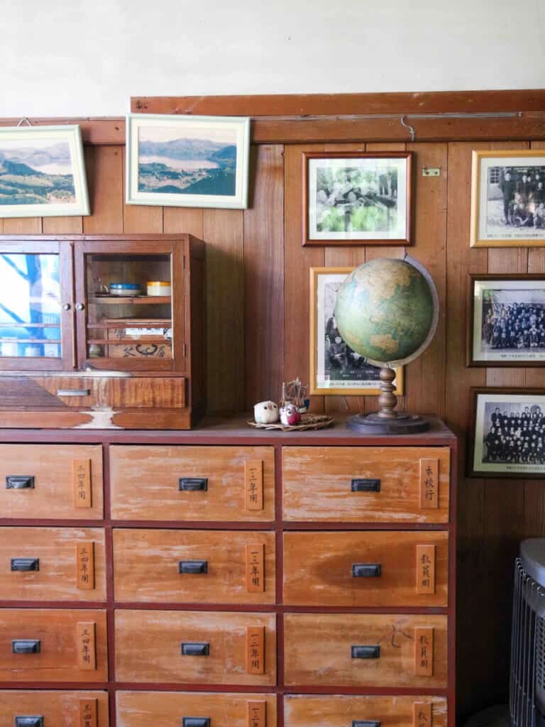 Drawers and old photos plus a globe inthefaculty room, all wooden