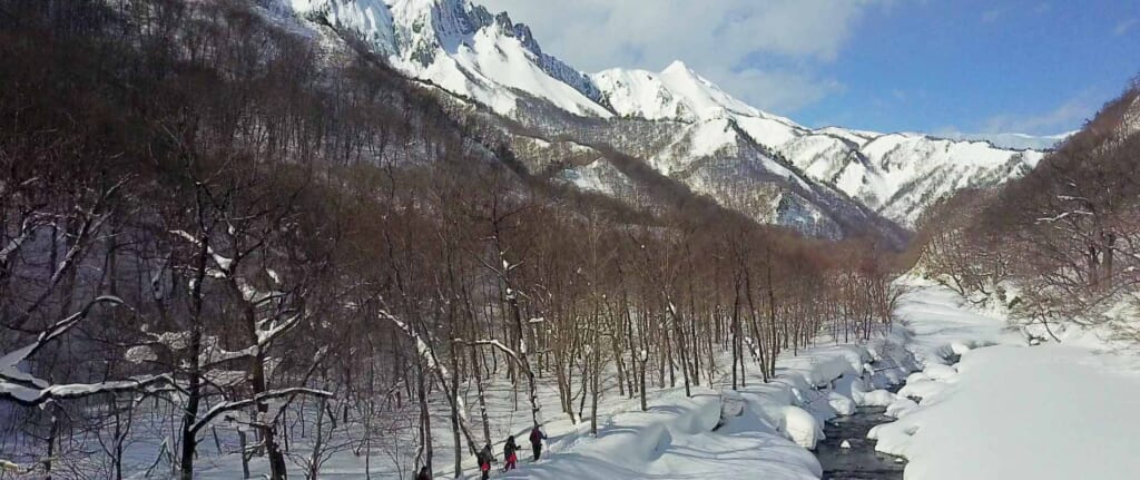 snowy mountains with people backcountry skiing in Japan