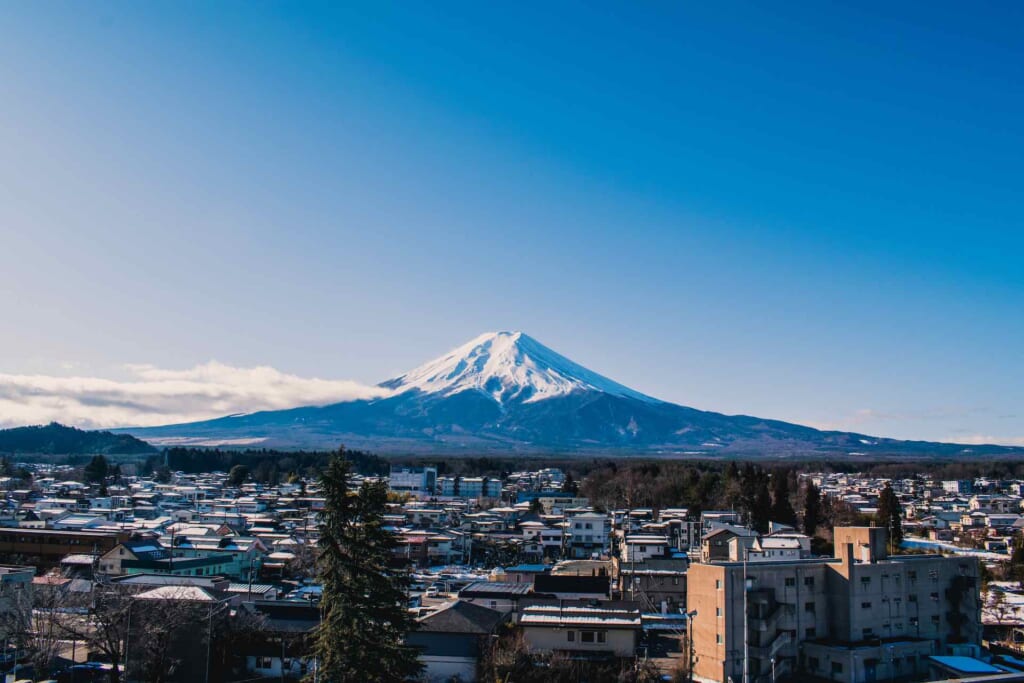 mount fuji with snow and city in the foreground