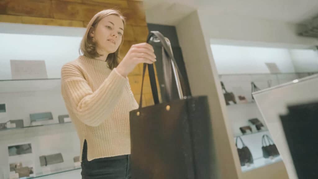 female holding a leather handbag