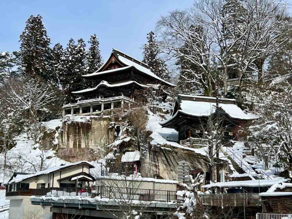 Japanese temple on cliff covered in snow in Fukushima prefecture
