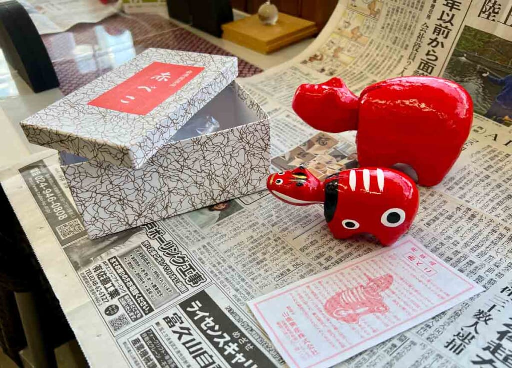 red 'akabeko' cow figurine on newspaper in Japan