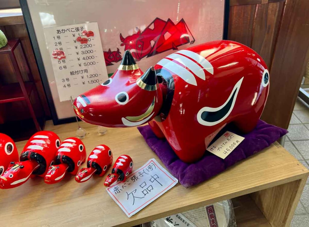 small and large red cow figures, one of Fukushima's popular souvenirs