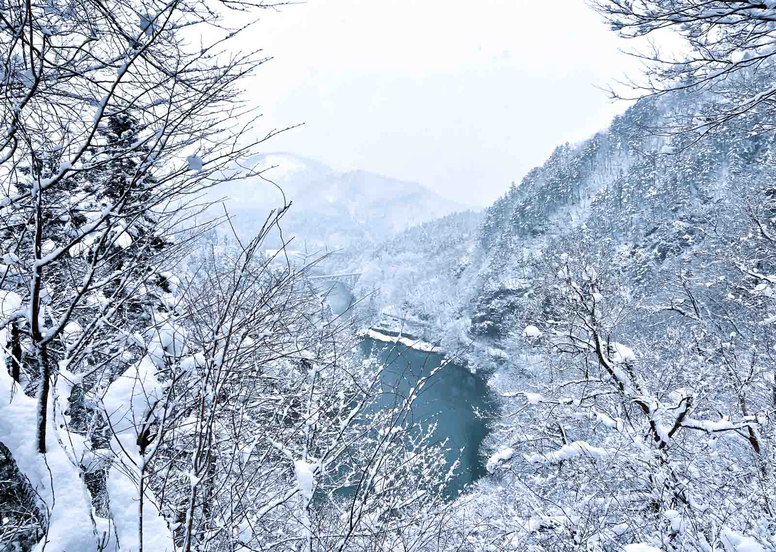 snowy mountains and blue valley with bridge in fukushima prefecture, japan