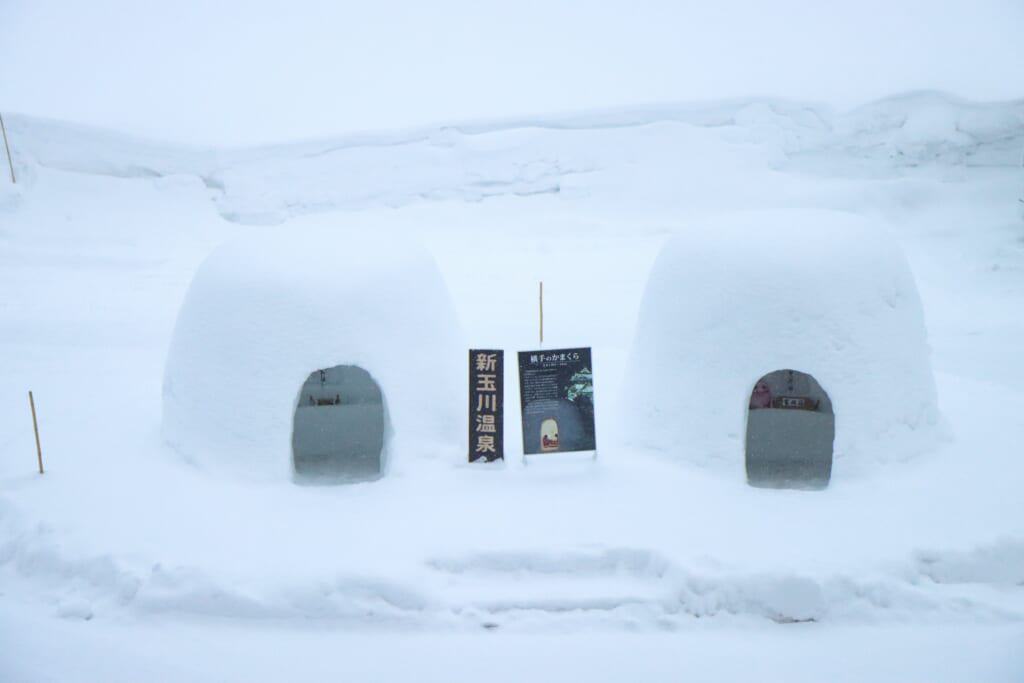 Two snow huts in front of the hotel lobby in Semboku, Akita, Japan