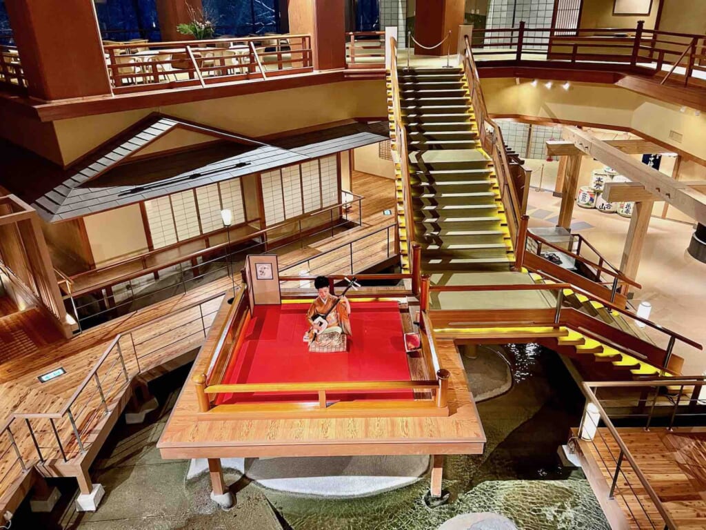 shamisen player in lobby of Ookawaso, Fukushima, famed for its similarity to Demon Slayer's Infinity Castle