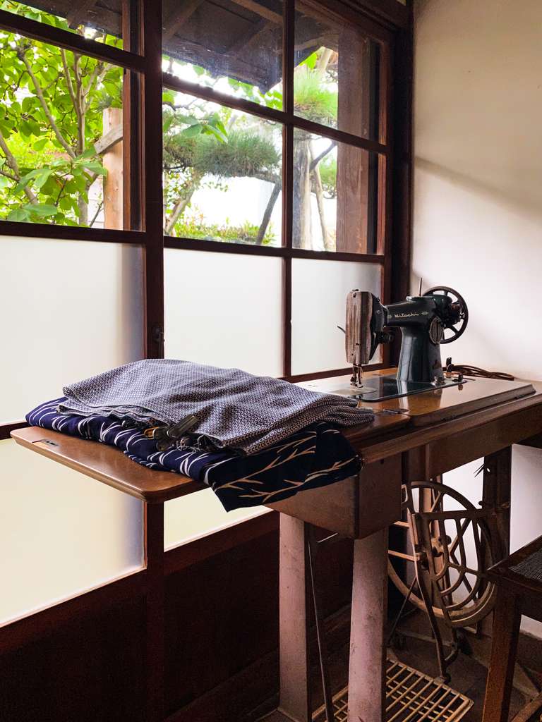 old sewing machine and cloths on table in Japanese workshop