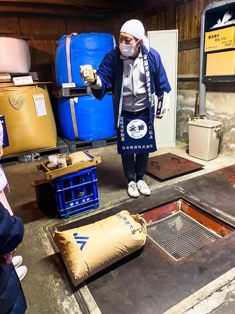 man giving tour of soy sauce making process in a traditional Japanese brewery in Japan