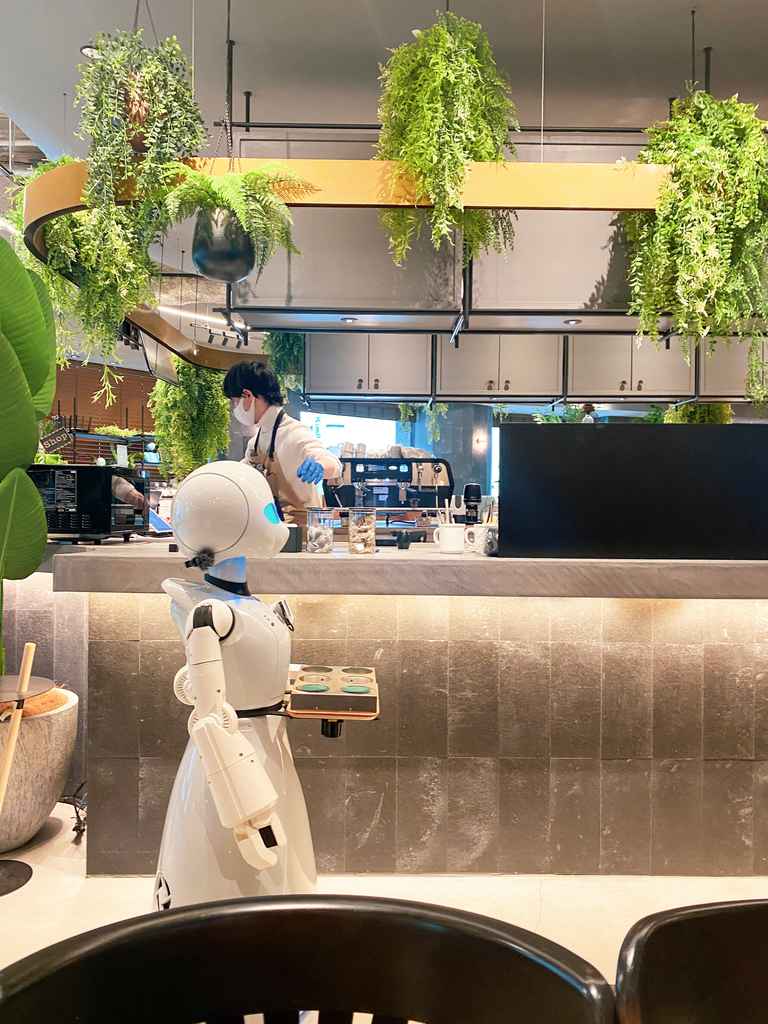 robot with tray passing by counter of a japanese restaurant in japan