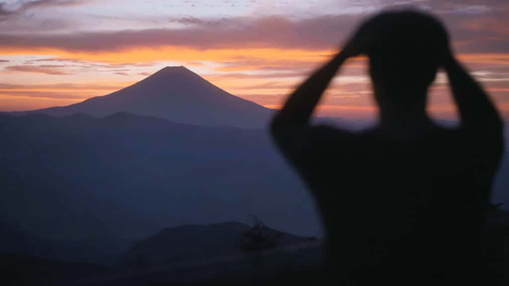 Mt. Fuji during sunset and a person infront