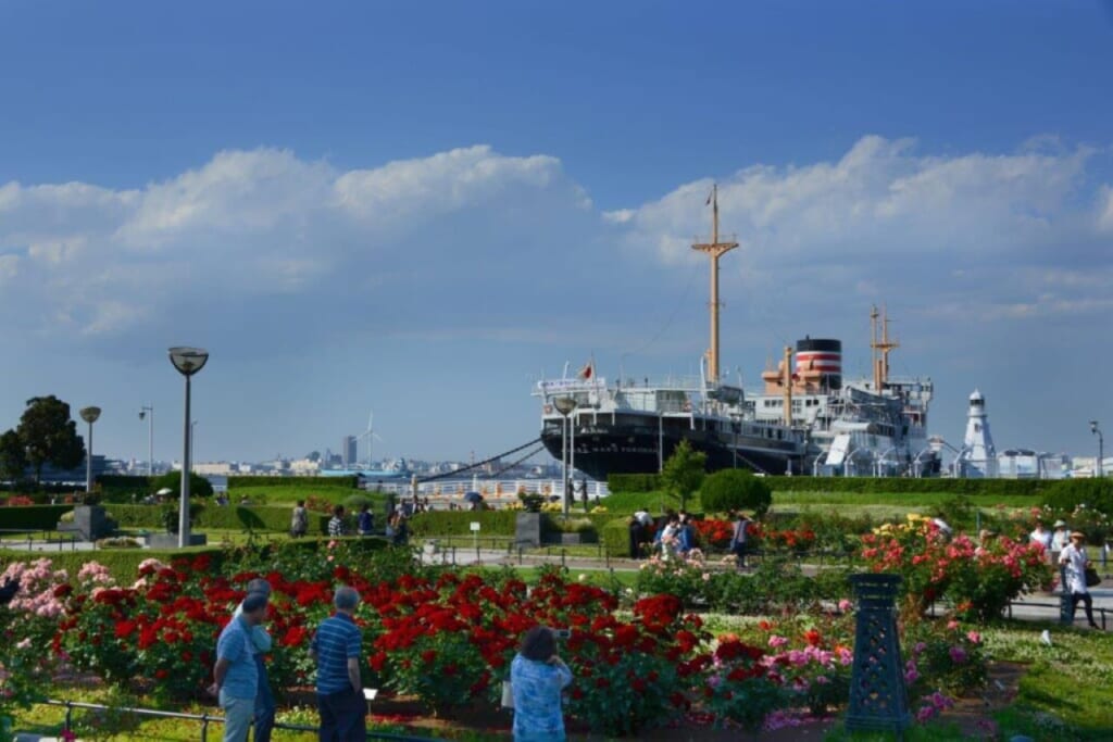 Visitors to Yamashita Park admiring the flowers and the view of Yokohama Bay.