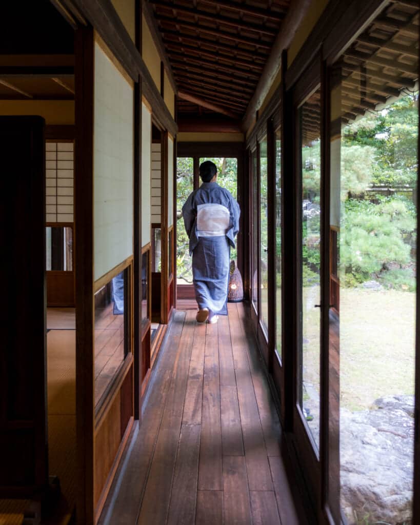 woman in kimono walking down engawa hallway