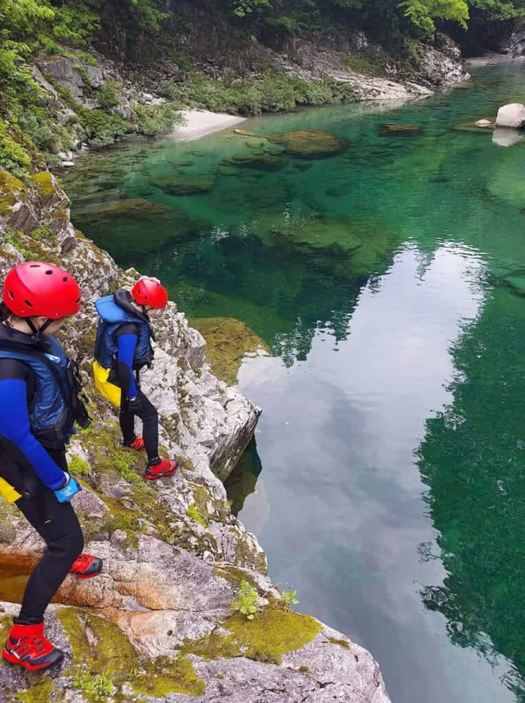 Canyoning at Kurobe River, two people looking at body of water