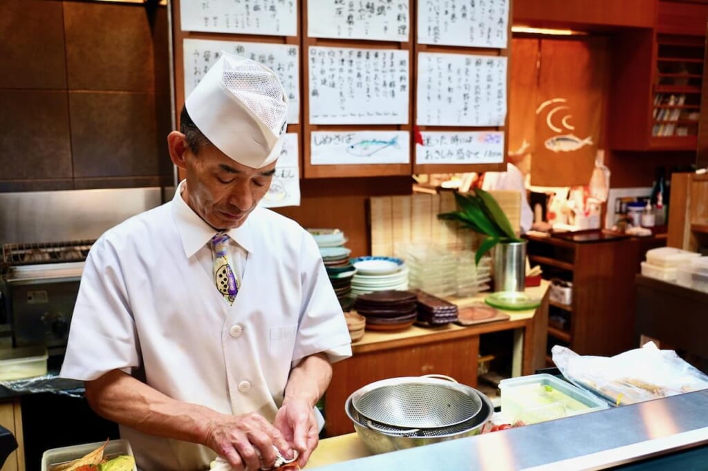 Hamoji chef wearing fugu tie cleans decorative leaves