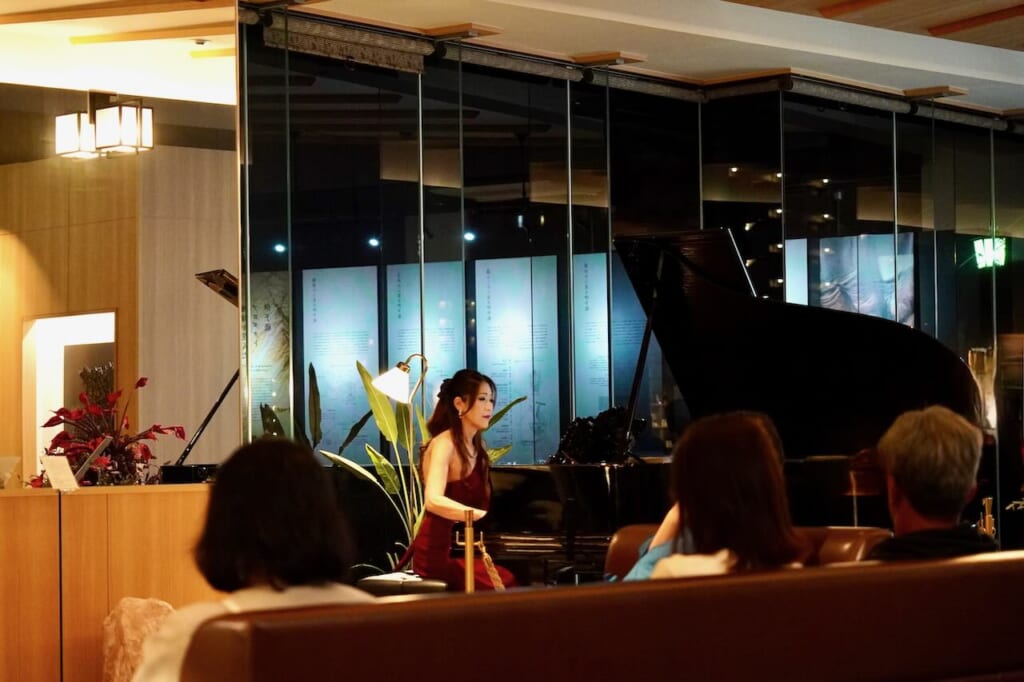woman playing grand piano in lobby