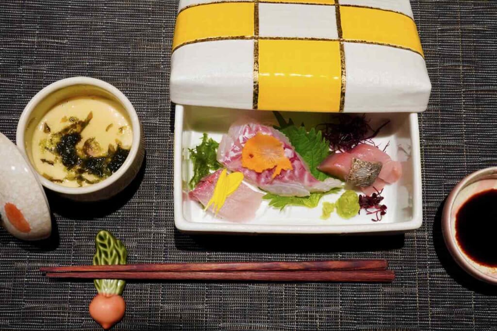 sashimi dish served in painted ceramic ware on placemat