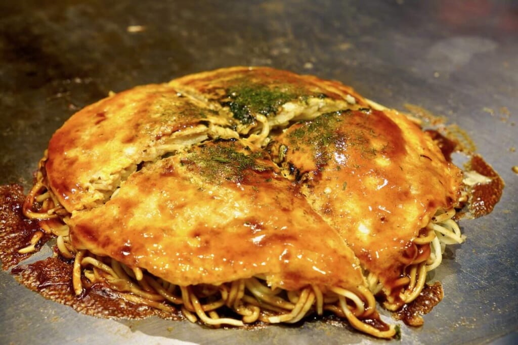 finished and sliced okonomiyaki on grill