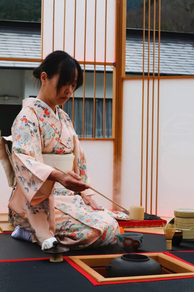 woman dressed in kimono pouring ceremonial tea