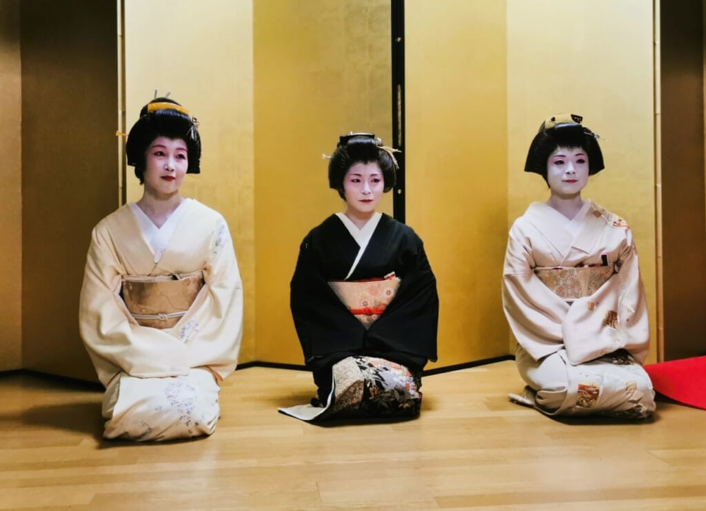 three geisha sitting seiza in a row