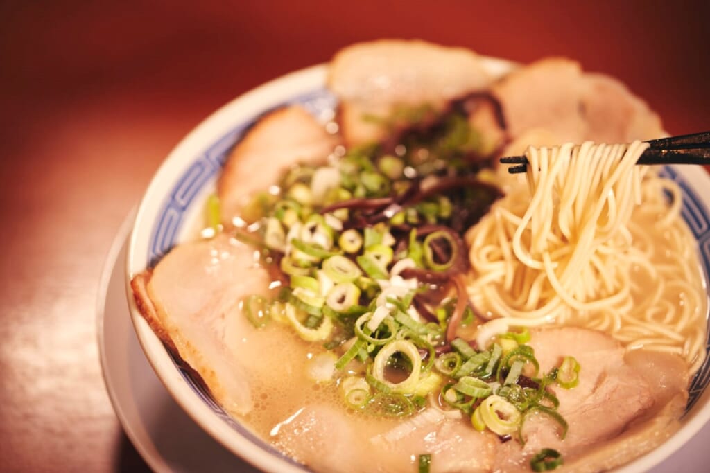 A tonkatsu ramen in Fukuoka with meat, spring onion and noodles