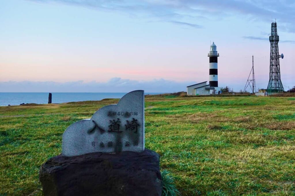 Cape Nyudozaki stone monument with lighthouse in distance