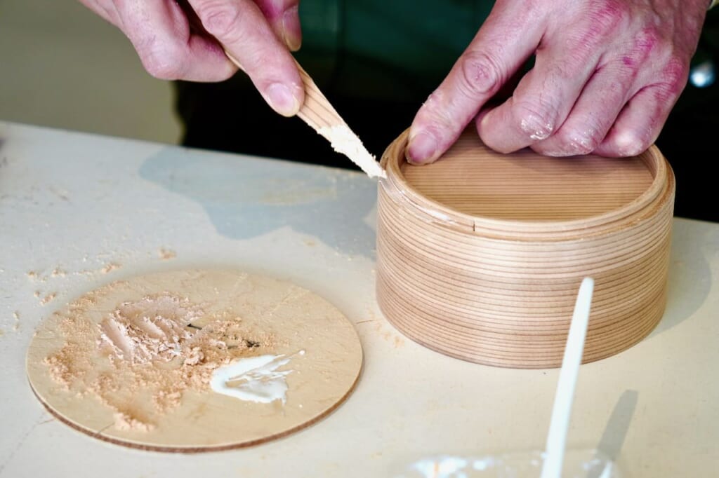Odate magewappa workshop, applying glue to round bento box