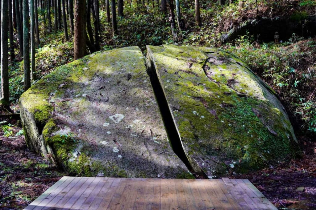 Dappled light on a mossy boulder that is split in two, called Itto-seki