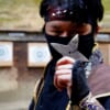 Ninja holding a throwing star in front of a practice range