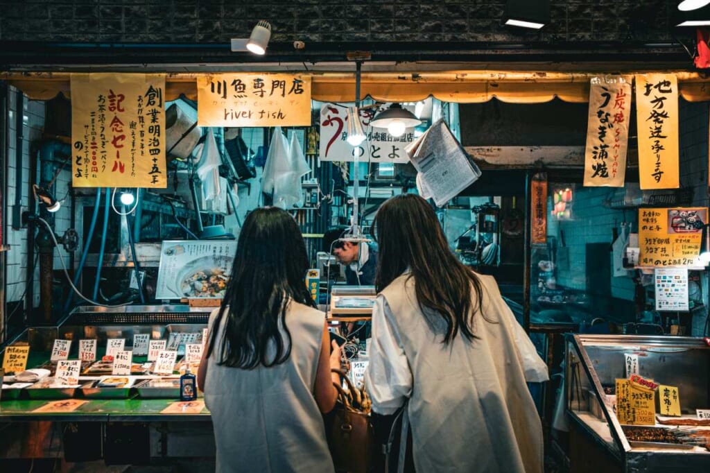 Two women at a food stall on the Nishiki market