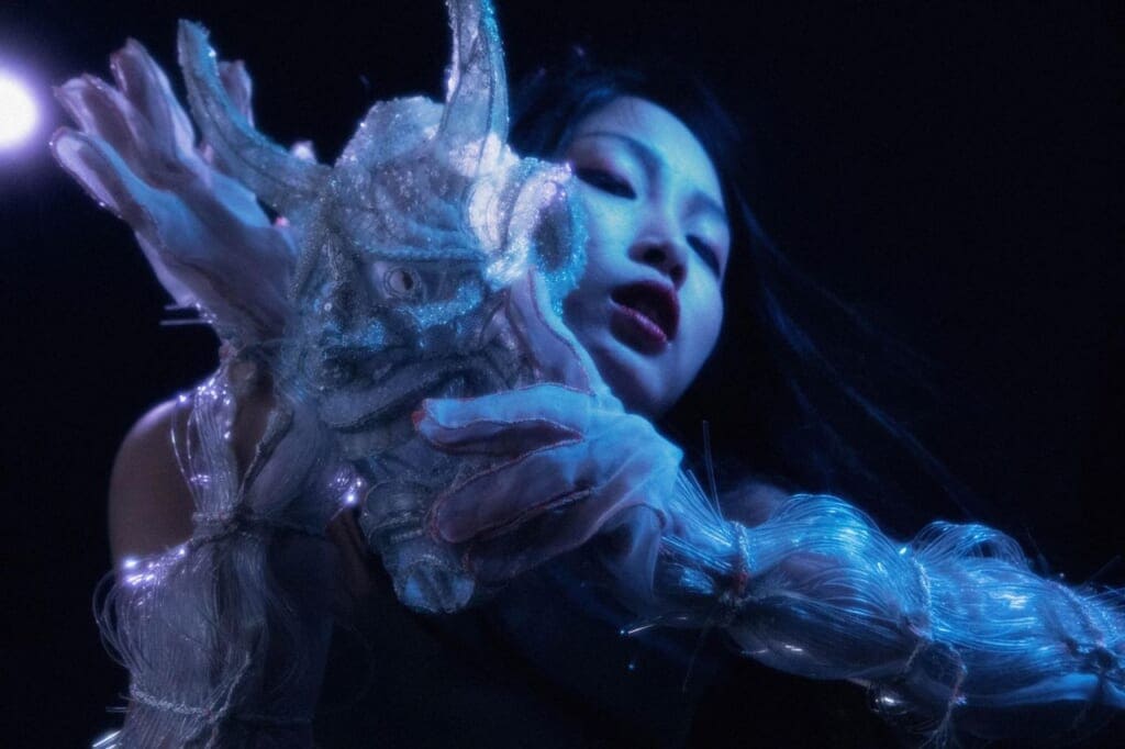 Butoh dancer holding sparkly mask