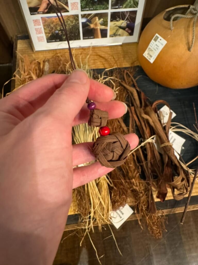 A woman's hand holding a craft keychain made out of dried leaf