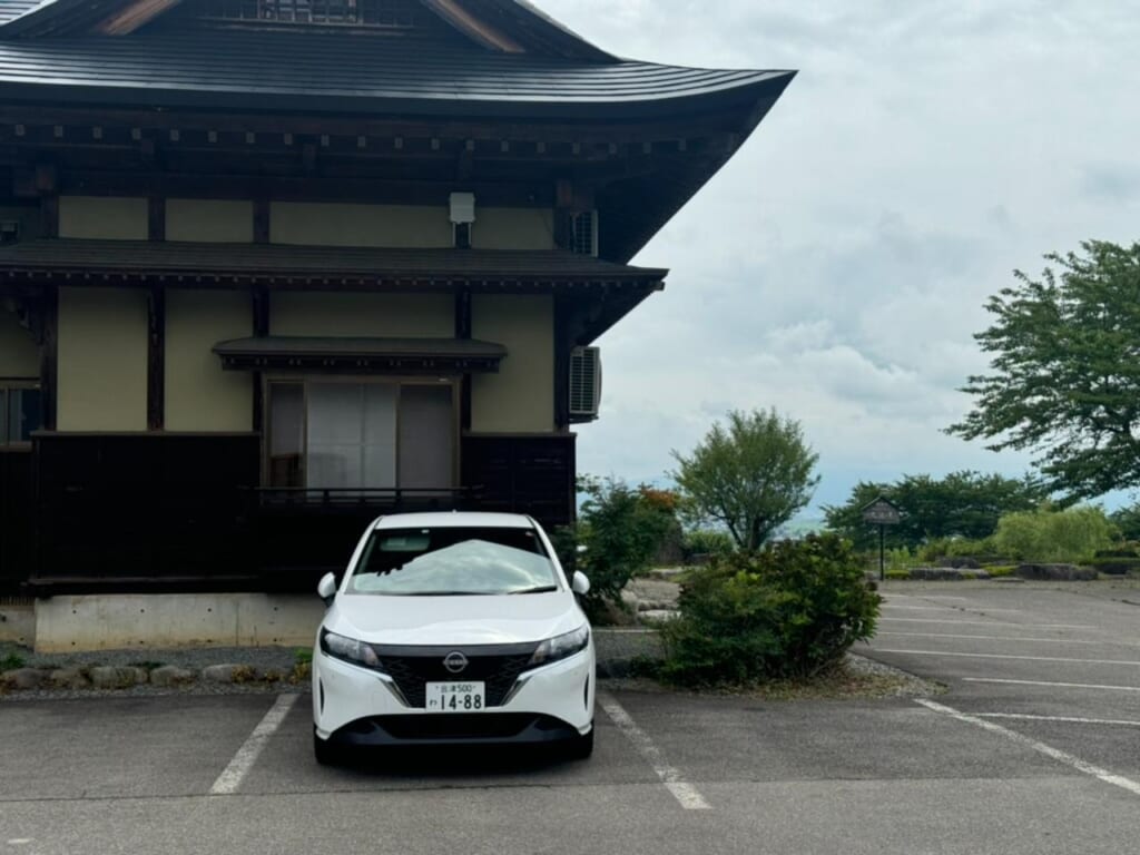 A white car in front of a Japanese building