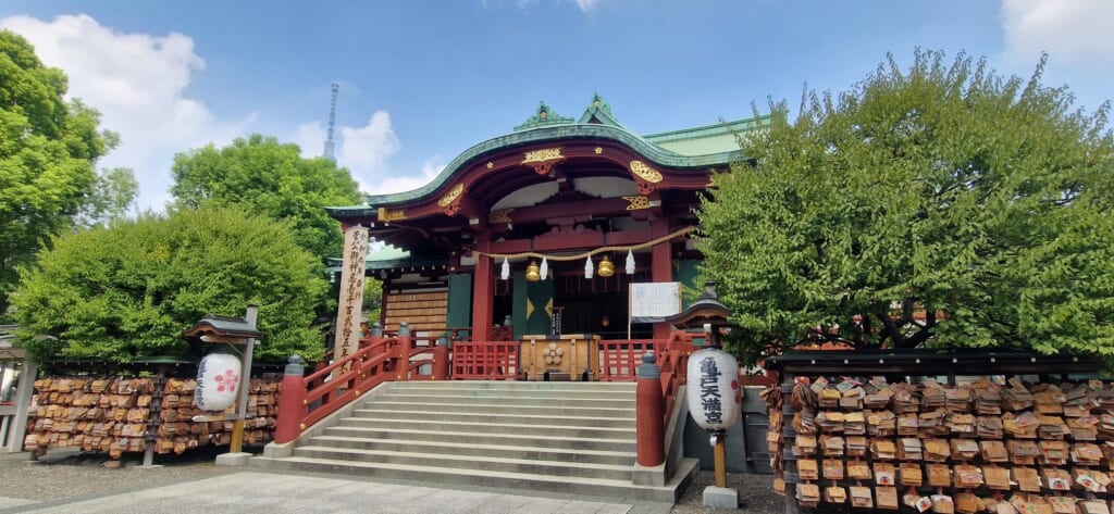 main building of the kameido tenjin shrine with tokyo skytree in the background